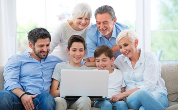 A family looking at a laptop all together happy